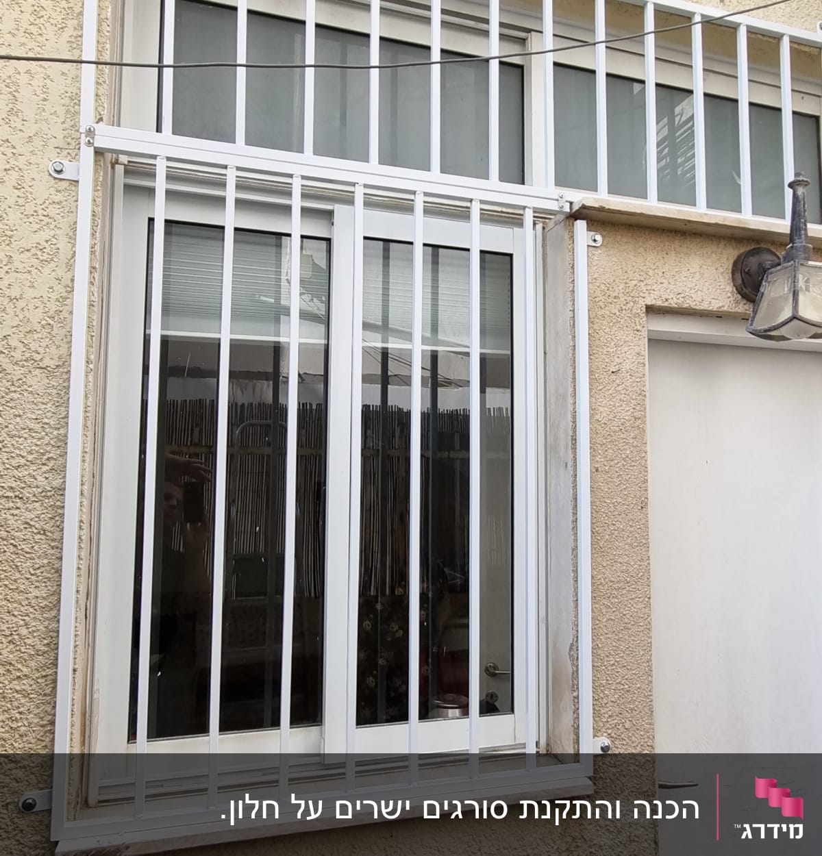 חלון עם סורגים לבנים על קיר חיצוני